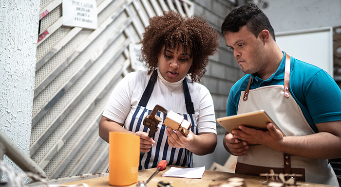 A young man and woman working together using tools