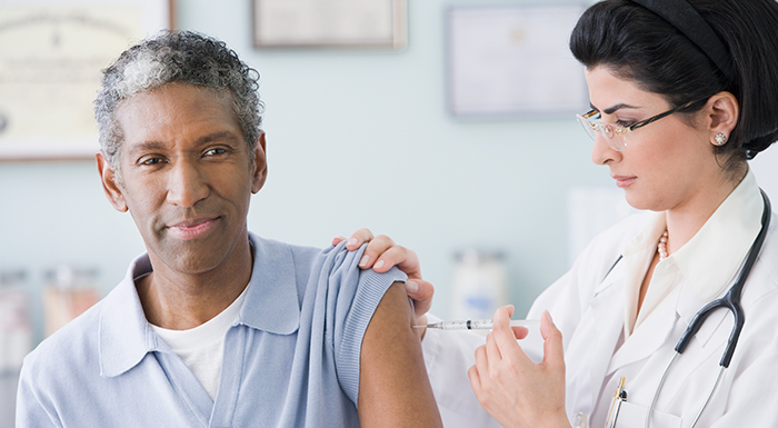 Picture of a woman administering a vaccine to a man