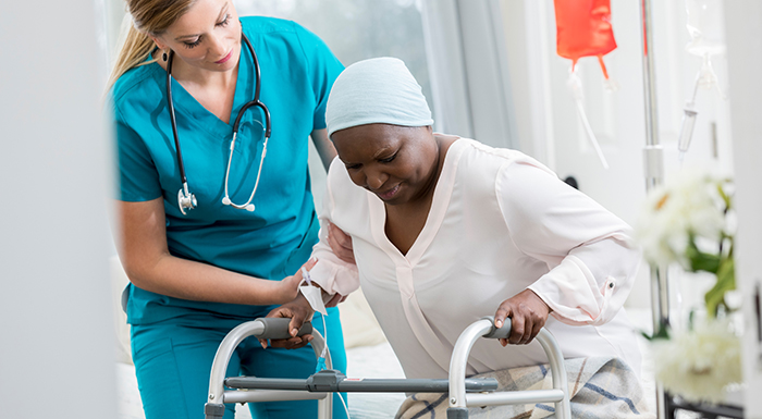 Picture of a young woman assisting an older woman with a walker