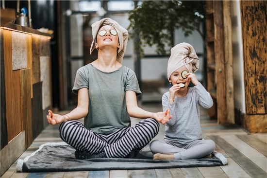 Woman and child sitting calmly with cucumbers on eyes