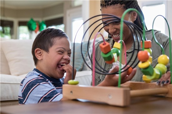 Laughing woman and child play with a toy 