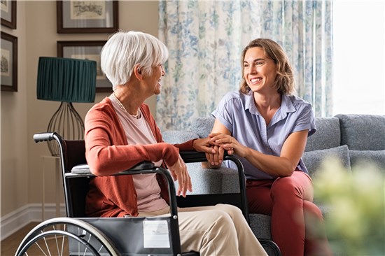 Woman and woman in wheelchair having smiling conversation