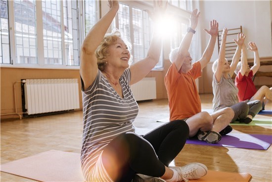 Group does yoga in sunny studio